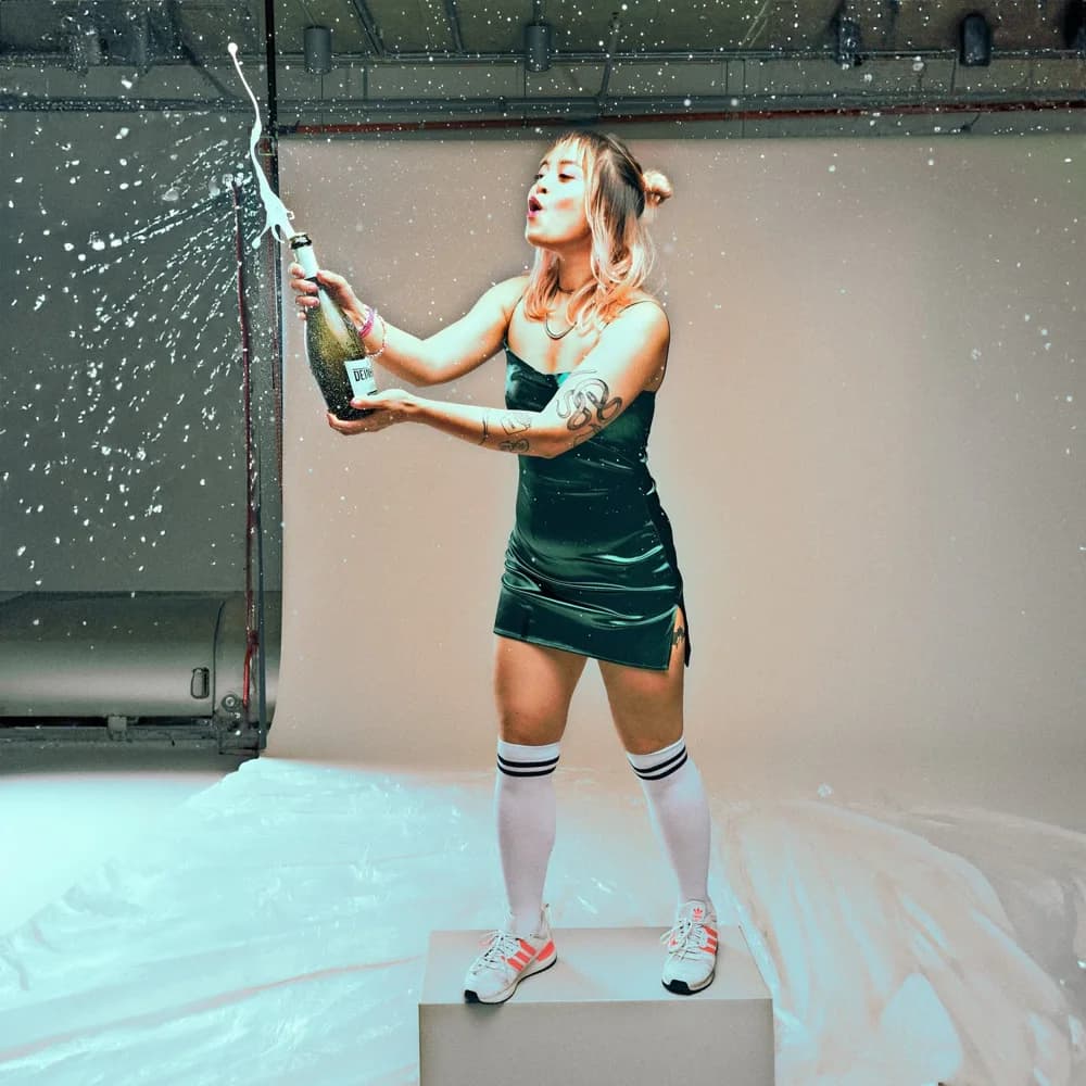 A woman spraying champagne, studio shot